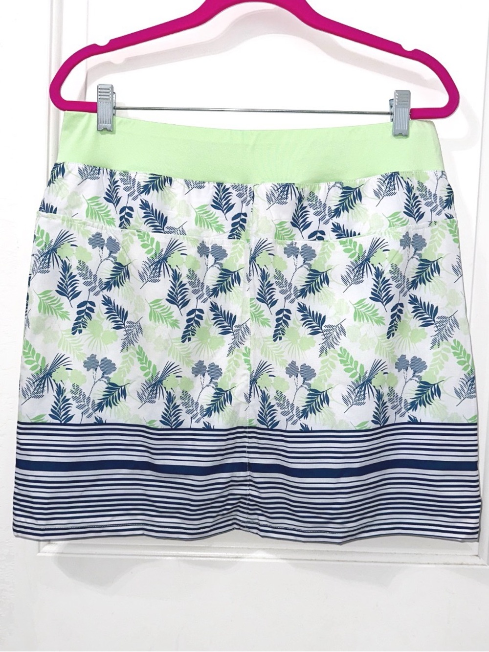 Tee Time golf skort features a vibrant green and navy blue leaf pattern